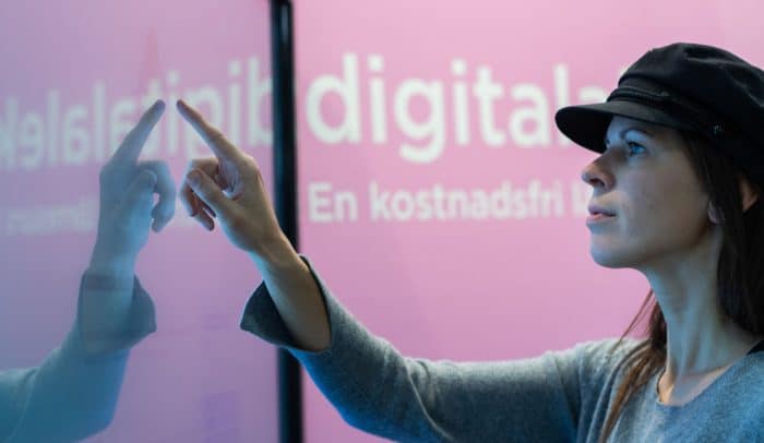 Kvinna framför stor pekskärm