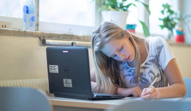 Ung tjej skriver i skolan.