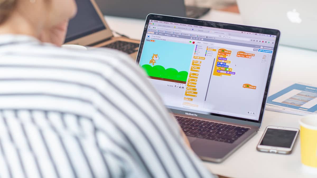 Person arbetar vid laptop med programvara som lär barn att programmera