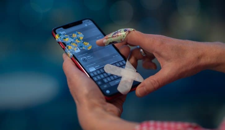 En person loggar in på sjukappar med en omplåstrad mobiltelefon.