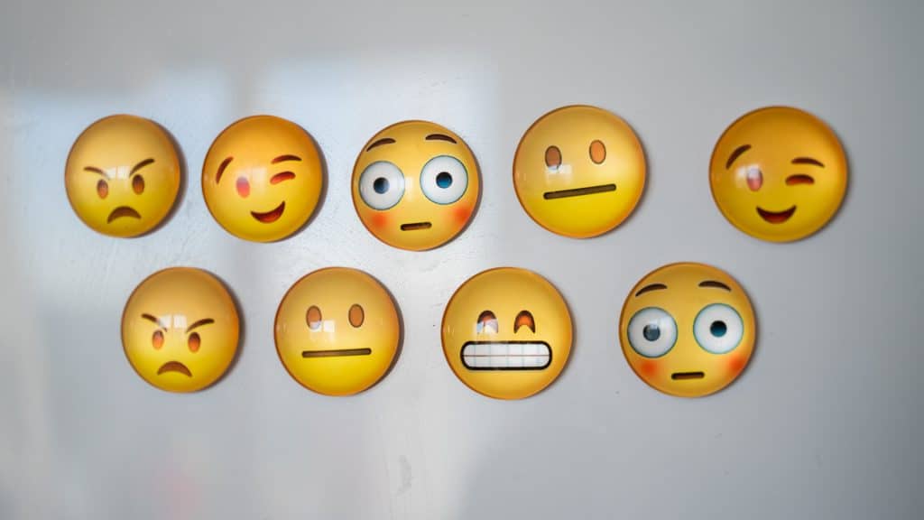 Emojis med olika uttryck på vit yta.