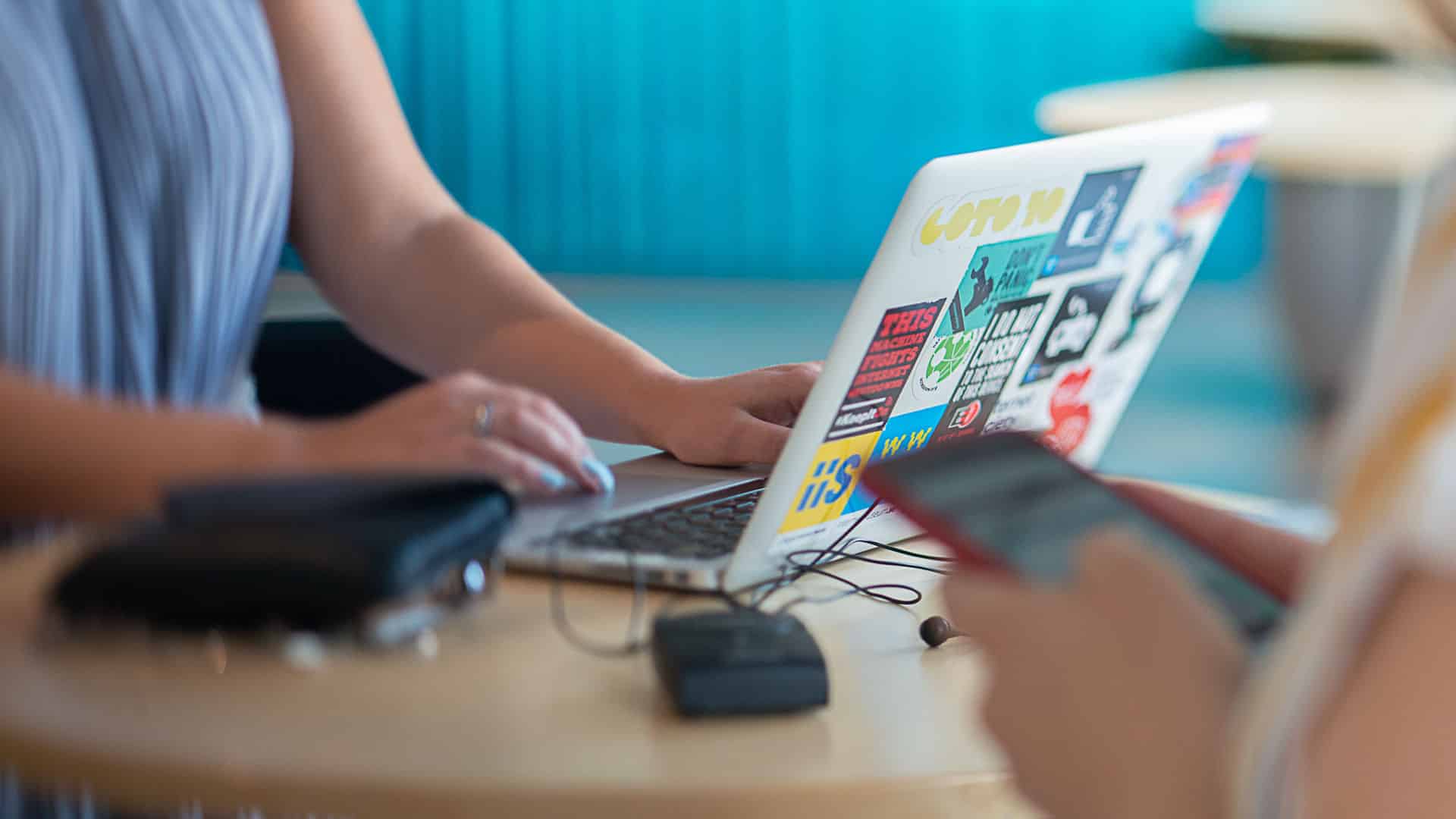 En kvinna sitter och skriver på en laptop