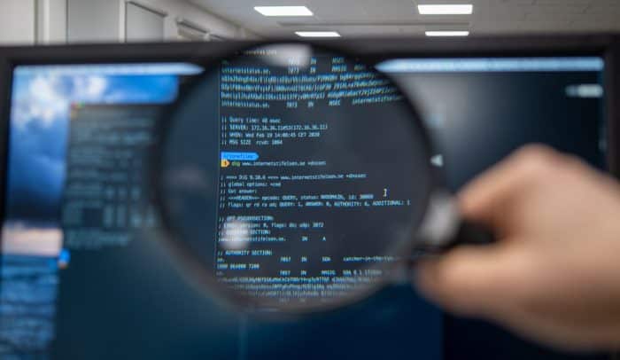 Magnifying glass investigating computer screen