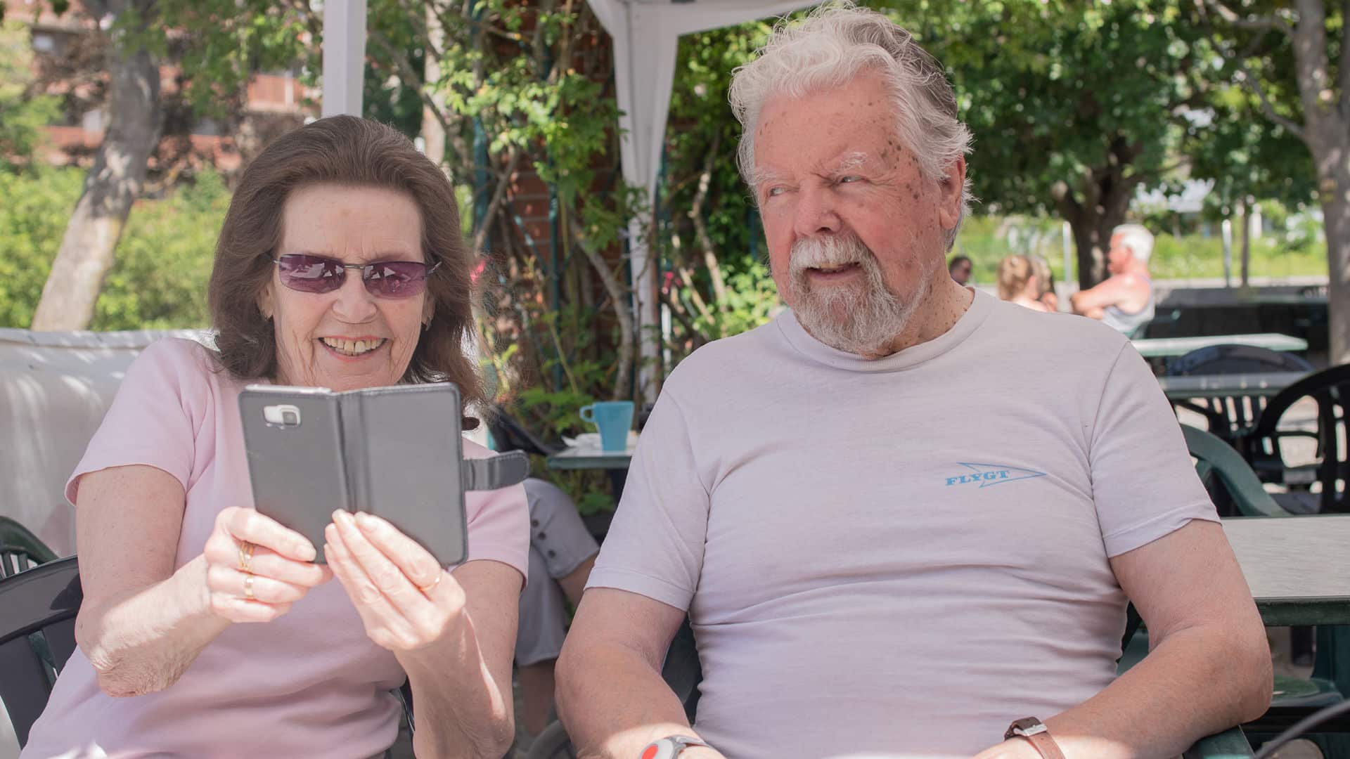 Äldre par som tillsammans tittar på en mobil