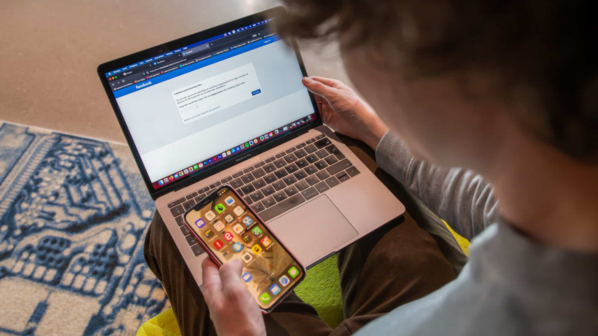 Person loggar in med sin dator och mobiltelefon.