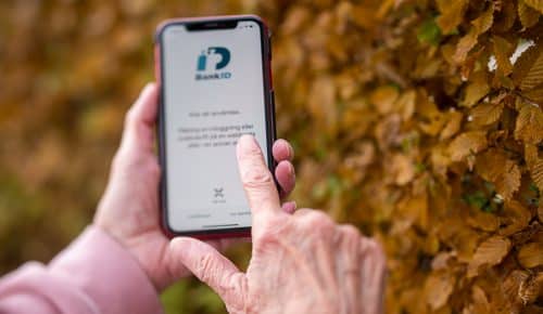 Äldre kvinna använder mobilt bank-id