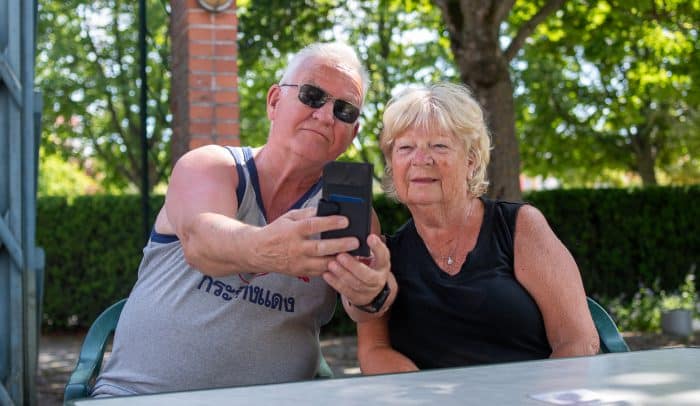 Ett äldre par tar en selfie i trädgården