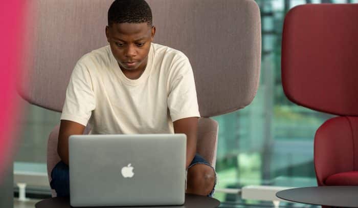En ung kille tittar ner på sin dator