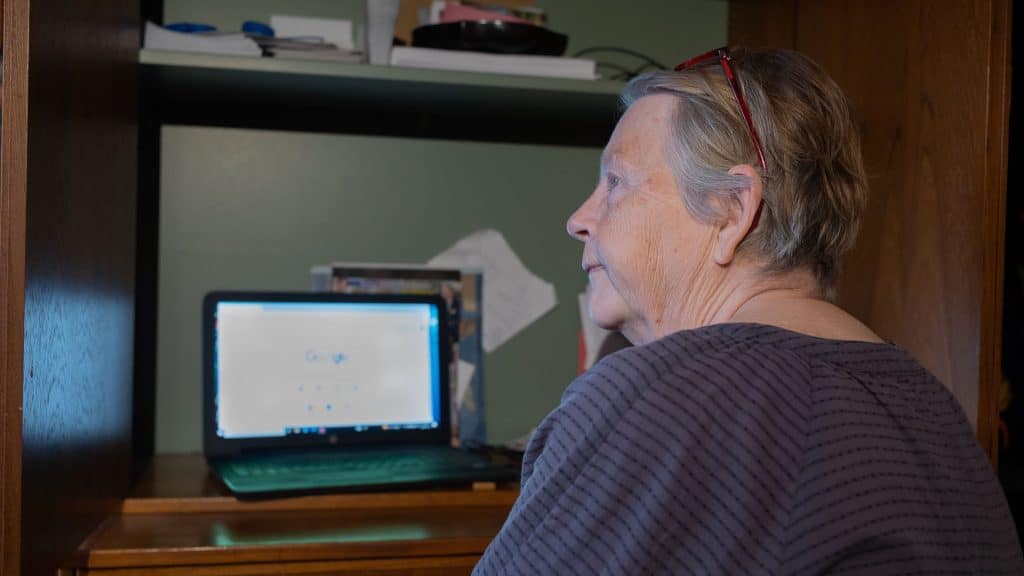 Pensionär som sitter framför datorn.