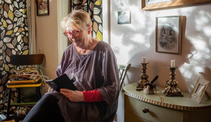 Pensionär som använder internet på sin mobiltelefon.