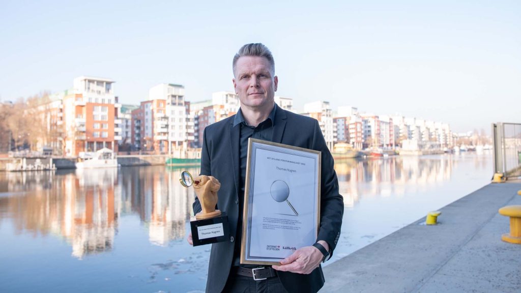 Thomas Nygren står med sitt pris Det gyllene förstoringsglaset, och diplom vid Hammarbykanalen i Stockholm