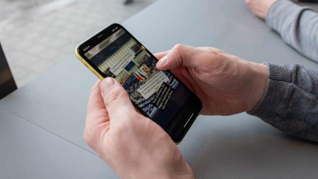 Händer som håller en mobiltelefon med politisk information på Instagram