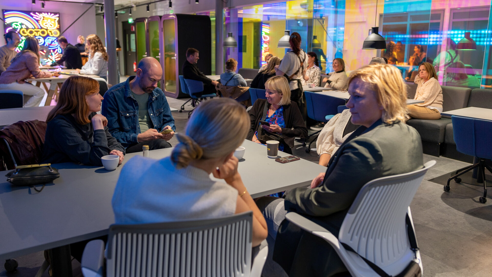 Folk i grupp sitter vid ett bord och arbetar.