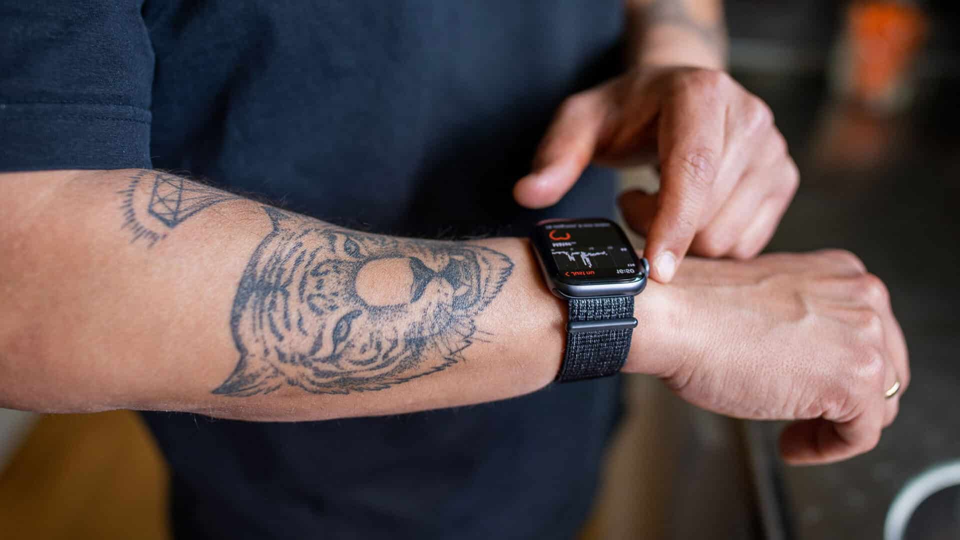 En tatuerad arm med en smartklocka på.