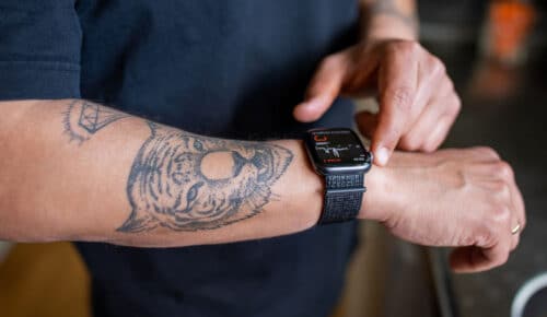 En tatuerad arm med en smartklocka på.