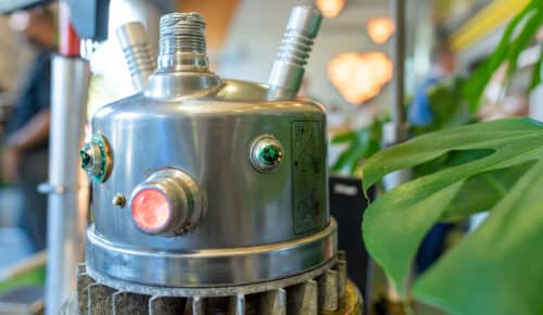 En robot i plåt med gröna lampor som ögon.
