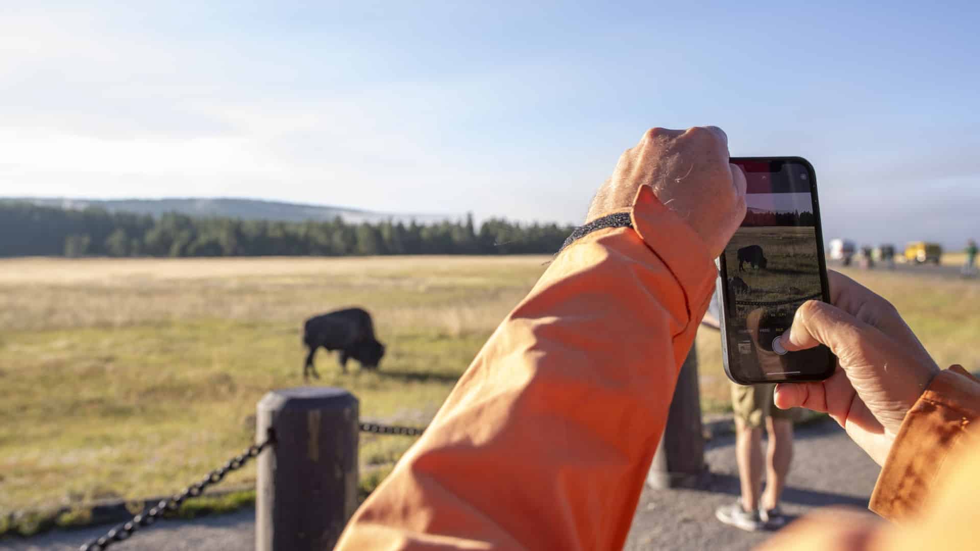 En person håller upp mobilkameran och tar en bild av en vacker vy.
