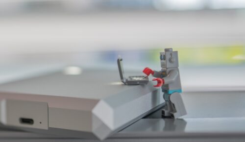 En liten legorobot skriver på en legodator.