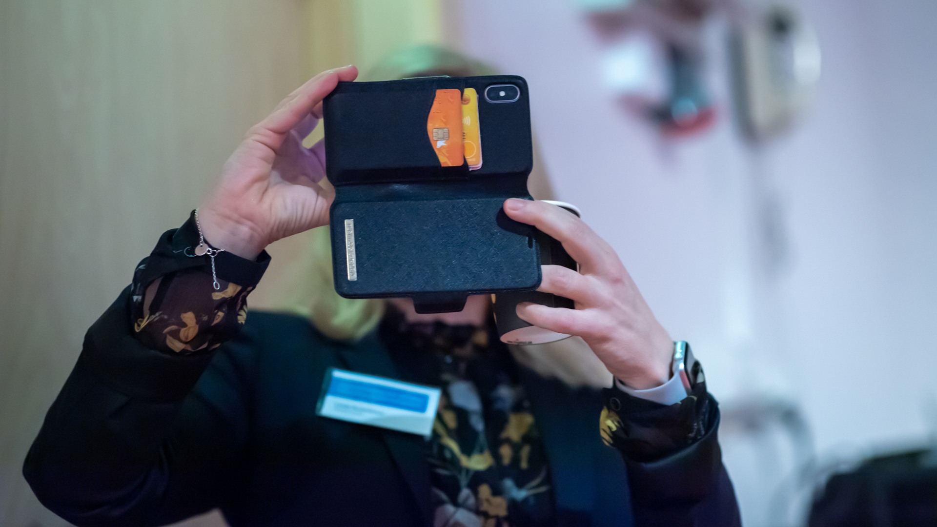 En kvinna som håller en mobiltelefon upp mot ansiktet.