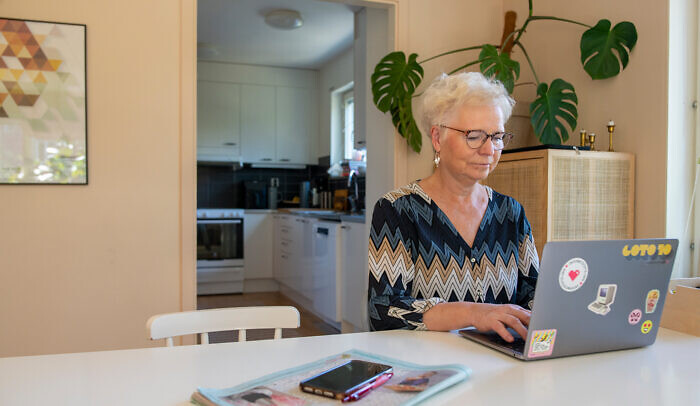 En kvinna sitter vid en laptop.