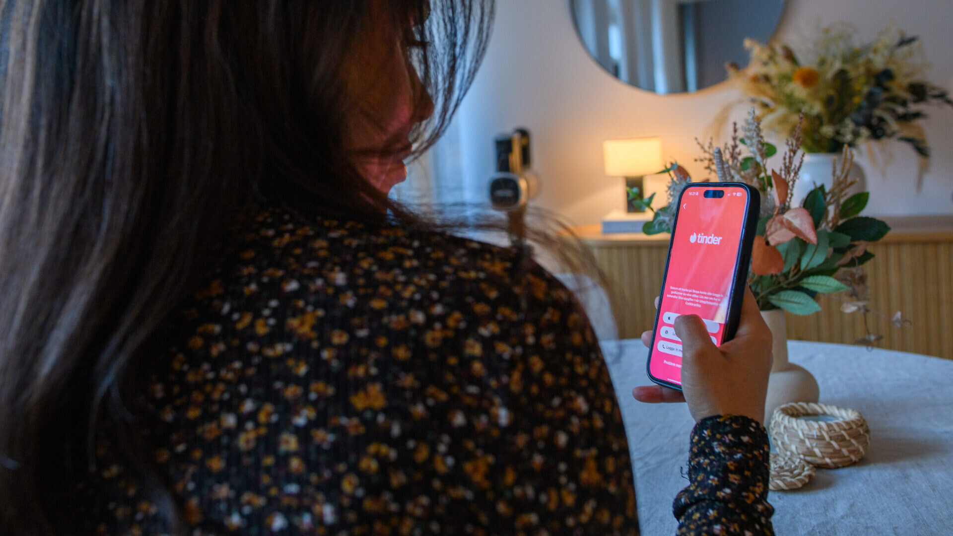 Kvinna som startar Tinder på sin mobiltelefon.