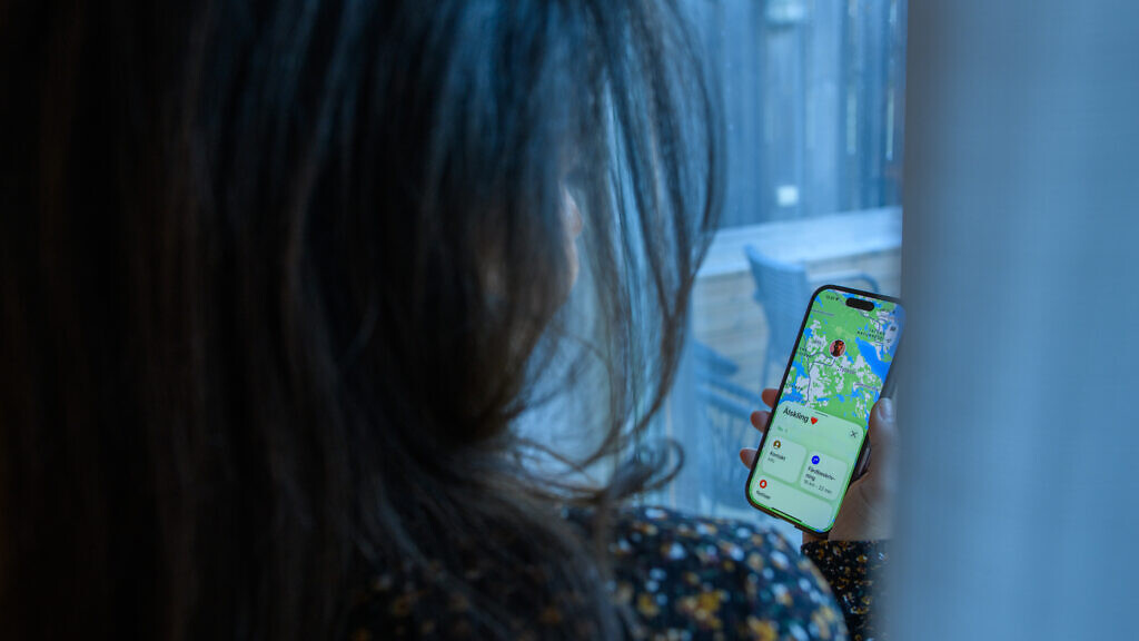 Kvinna som följer sin partner genom mobilens platstjänster.