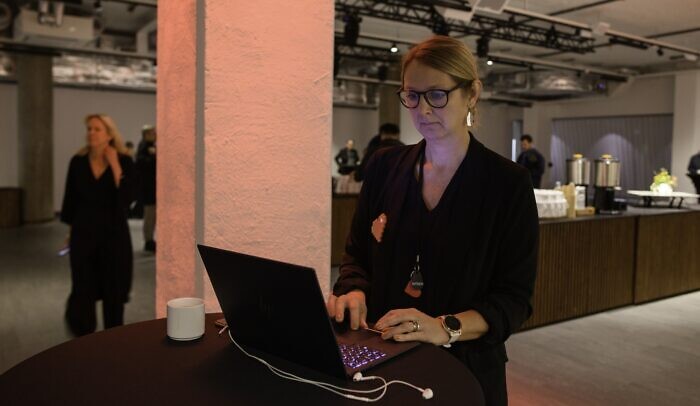 En kvinna i glasögon använder en bärbar dator.