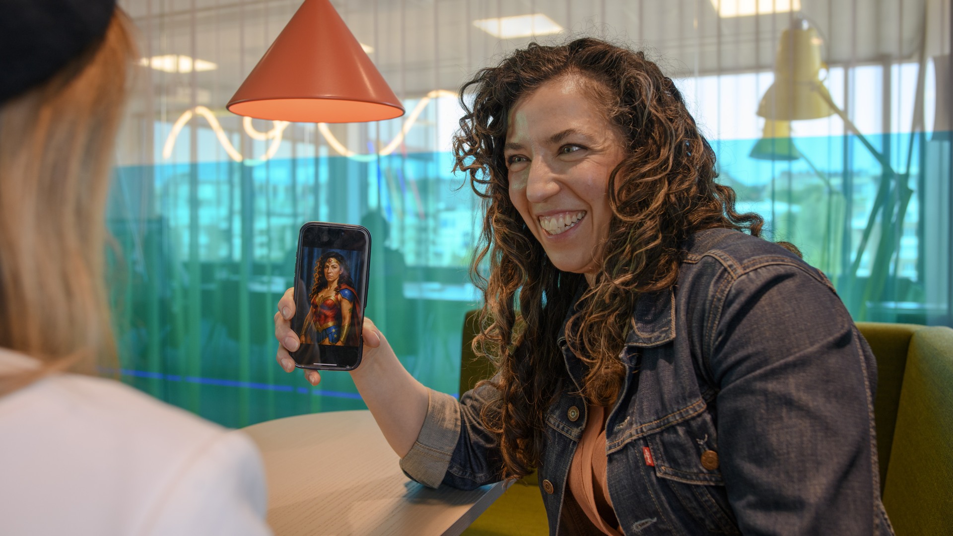 En kvinna sitter vid ett bord med en mobiltelefon.