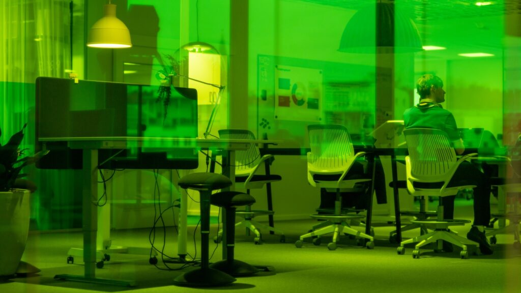 En man som sitter vid ett bord i en kontorsmiljö.