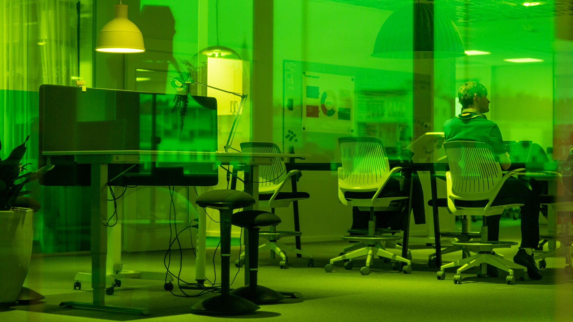 En man som sitter vid ett bord i en kontorsmiljö.