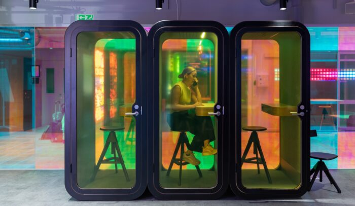 En person som sitter vid ett bord i ett telefonbås.