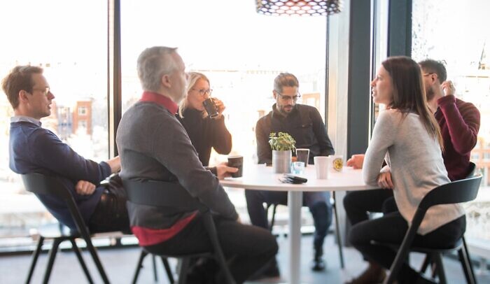 En grupp människor som sitter runt ett bord och pratar.