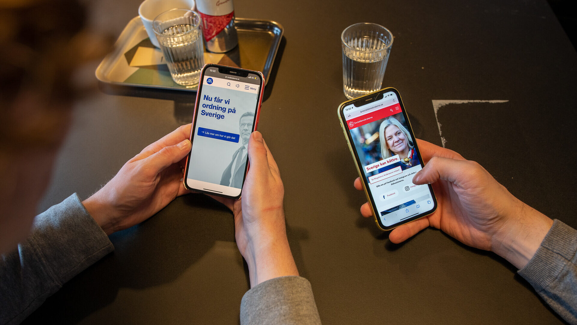 Två mobiltelefoner som visar två olika politiska annonser.