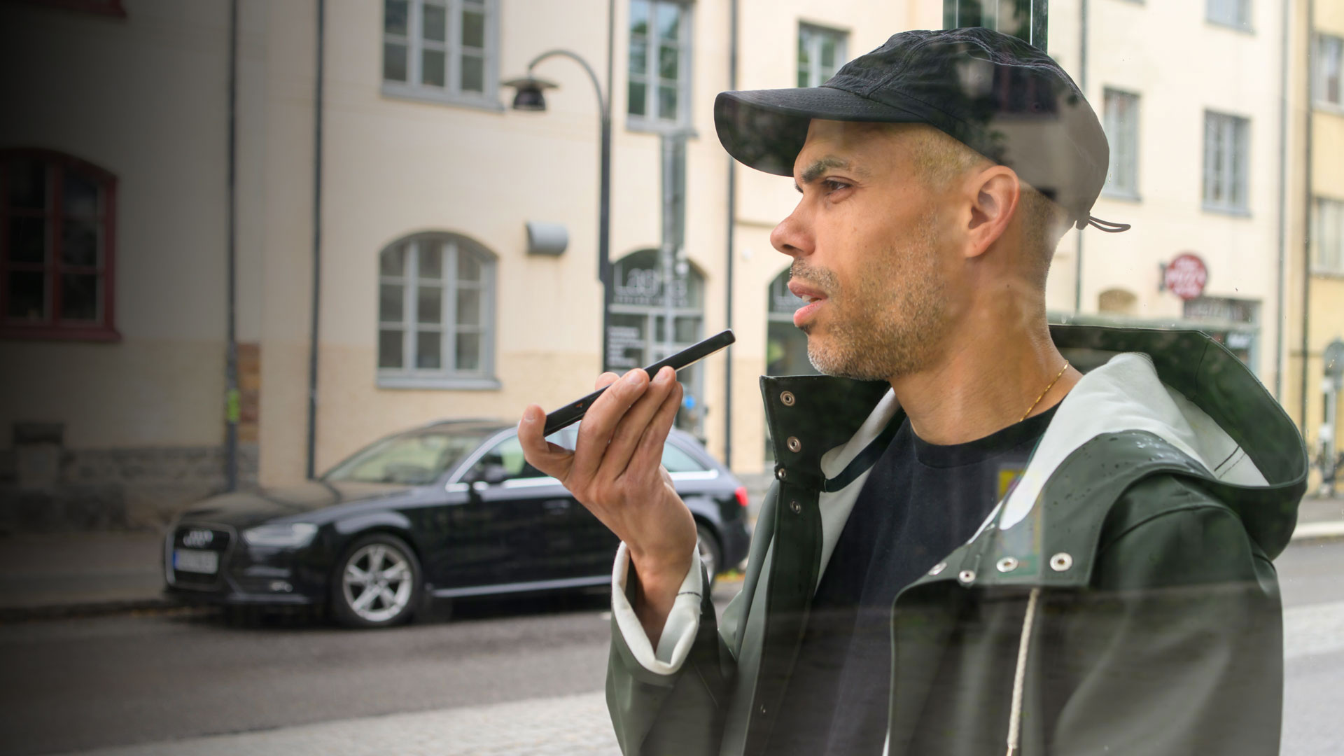 En man pratar i mobilen i högtalarläge.